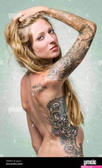 Studio portrait of tattoos body piercings on an attractive nude young woman Stock Photo