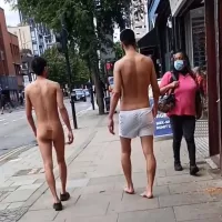 Two naked men spotting walking down street in broad daylight after attacking cyclist