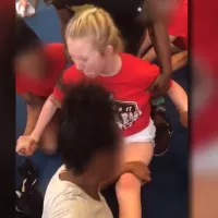 Cheerleading team caught on camera forcing screaming girl to do the splits