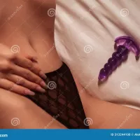 Silicone Anal Plug Next To Woman Girl with a Body in Underwear Lies on Bed in Bedroom. Female Sex Toys for Stock Photo