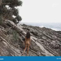 Wild Rocky Beach Landscape with Nudist Beach Woman Stock Photo