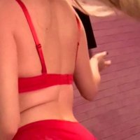 Hot blonde in red lingerie dancing a dildo on camera.